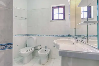 a white bathroom with a toilet and a sink at Villa Antao in Guia
