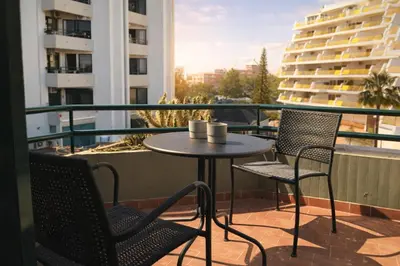 a patio with two chairs and a table on a balcony at Stylish Center Apartment Vilamoura in Vilamoura