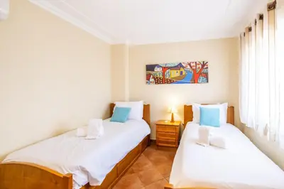 a bedroom with two beds and a painting on the wall at Villa Isabella in Albufeira