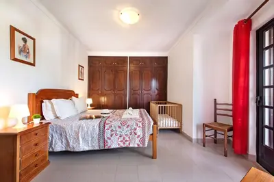 a dining room with a wooden table and chairs at Spacious 4 bedroom villa, private pool, free air conditioning and wifi in Quarteira