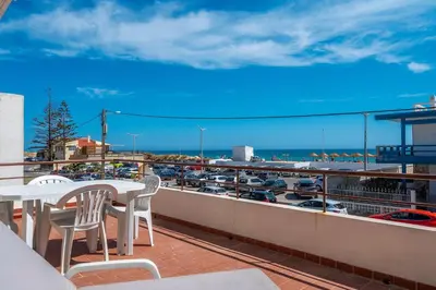 a balcony with a table and chairs and a view of a harbor at Sundance Beach House in Faro