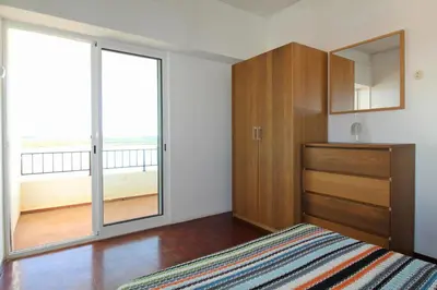 a bedroom with a bed and a large window at Sundance Beach House in Faro