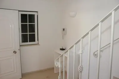 a white hallway with stairs and a window at Villa V2 X in Albufeira