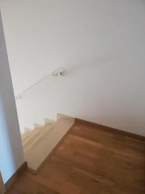 an empty room with stairs and white walls and wooden floors at Villa V2 X in Albufeira