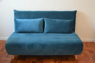 a blue couch with two blue pillows in a room at Casa aOrta Downtown in Faro