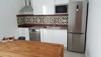 a kitchen with a refrigerator and a wooden table at Casa aOrta Downtown in Faro
