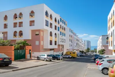 a city street with cars parked in a parking lot at Apartamento São Pedro do Mar in Quarteira