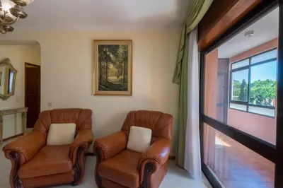 two leather chairs in a room with a window at Apartamento São Pedro do Mar in Quarteira