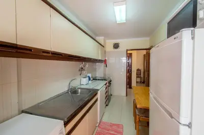 a kitchen with a sink and a refrigerator at Apartamento São Pedro do Mar in Quarteira