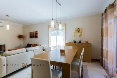 a dining room and living room with a table and chairs at GREICE HOMES 2 BEDROOM LUXURY APARTMENT VICTORIA BOULEVARD in Vilamoura