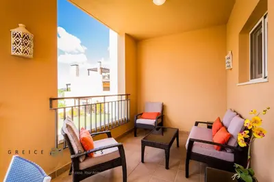 a balcony with two chairs and a window at GREICE HOMES 2 BEDROOM LUXURY APARTMENT VICTORIA BOULEVARD in Vilamoura