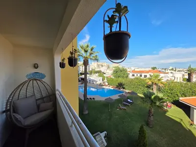 a balcony with a view of a pool and palm trees at Love Albufeira - Center, walk to the beach, Old Town, Oura Strip, top location in Albufeira