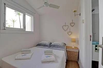 a white bedroom with a bed and a window at Vilamoura Golf Villa 1 With Pool by Homing in Vilamoura