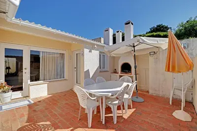 a patio with a table and chairs and an umbrella at Vilamoura Golf Villa 1 With Pool by Homing in Vilamoura