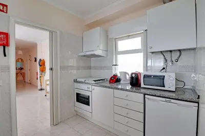 a kitchen with white cabinets and a microwave at Albufeira Concept 1 with Pool by Homing in Guia