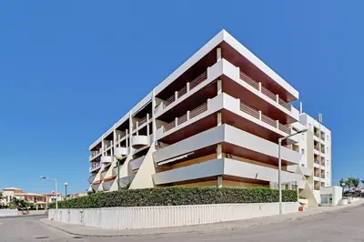 a large apartment building with balconies on a street at Albufeira Concept 1 with Pool by Homing in Guia