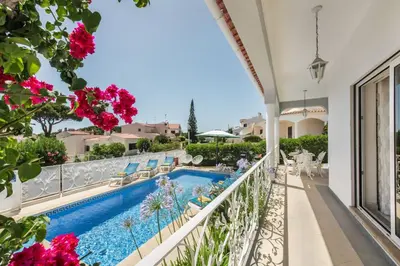 a pool with chaise lounge chairs and a swimming pool at Charming Villa With Private Pool in Vibrant Vilamoura, Free AC and Wifi in Quarteira