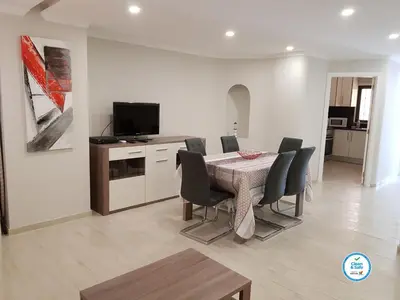 a dining room with a table and chairs and a television at Forte Beach- Albufeira in Albufeira
