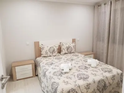 a bedroom with a bed with a floral bedspread at Forte Beach- Albufeira in Albufeira