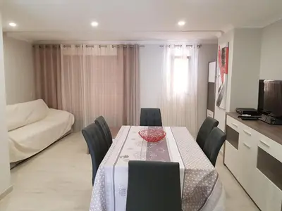 a dining room with a table with chairs and a couch at Forte Beach- Albufeira in Albufeira