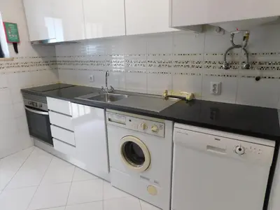 a white kitchen with a sink and a dishwasher at Sol Nascente Garden in Vilamoura