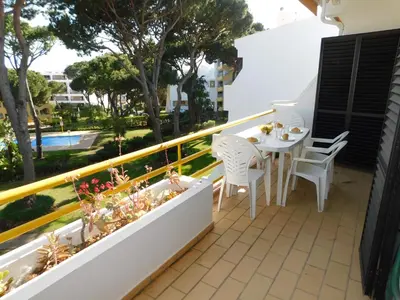 a white table and two chairs on a balcony at Sol Nascente Garden in Vilamoura