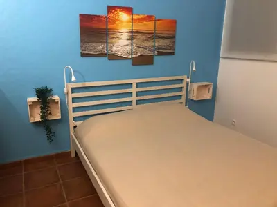 a bedroom with a bed with three paintings on the wall at Studio - Praia da Falesia - Algarve in Albufeira