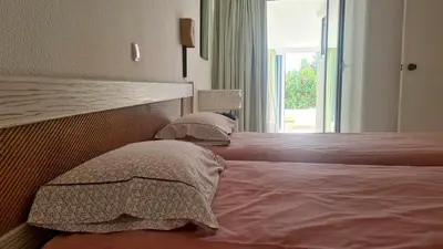 a bedroom with two beds with pillows and a window at Albufeira, with terrace, see views, 5 min to beach (21) in Albufeira