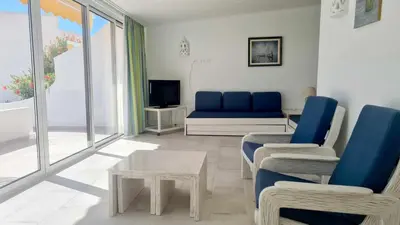 a living room with a blue couch and a table at Albufeira, with terrace, see views, 5 min to beach (21) in Albufeira