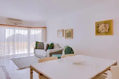 a white living room with a couch and a table at Varandas do Sul - Near Vilamoura Marina in Vilamoura
