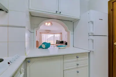 a kitchen with white cabinets and a large mirror at Varandas do Sul - Near Vilamoura Marina in Vilamoura