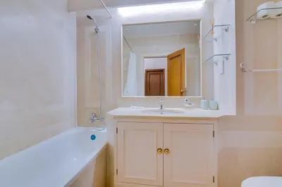 a bathroom with a sink and a tub and a mirror at Varandas do Sul - Near Vilamoura Marina in Vilamoura