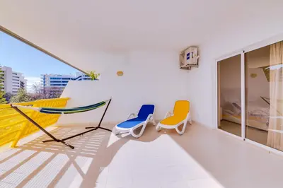 a balcony with two chairs and a bed at Varandas do Sul - Near Vilamoura Marina in Vilamoura
