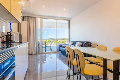 a kitchen and living room with a table and chairs at Marina View Apartment By VilamouraSun in Vilamoura