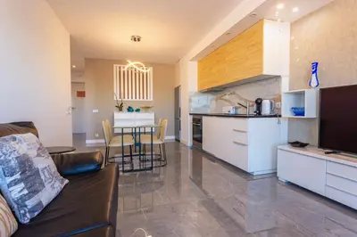 a kitchen and living room with a couch and a table at Marina View Apartment By VilamouraSun in Vilamoura