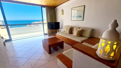 a living room with a couch and a view of the ocean at Albufeira, One step to the beach (13) in Albufeira