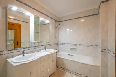 a bathroom with two sinks and a tub and a mirror at VR Galé Mar in Albufeira