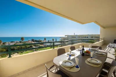 a balcony with a table and chairs and the ocean at VR Galé Mar in Albufeira