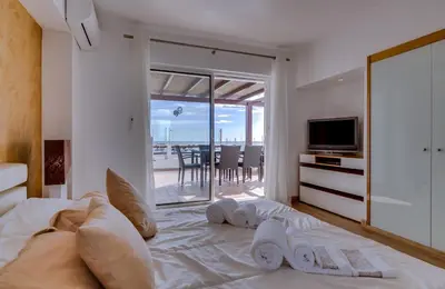 a bedroom with a bed with pillows and a television at Primula - Wonderful view - Vilamoura Marina in Vilamoura