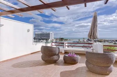 a patio with chairs and an umbrella and the beach at Primula - Wonderful view - Vilamoura Marina in Vilamoura
