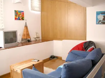 a living room with a blue couch and a tv at Welcoming House in Albufeira in Albufeira