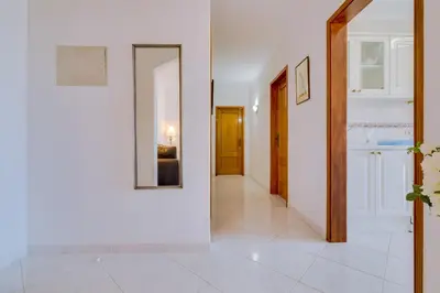 a hallway with white walls and a mirror at Falésia II - Nice Apartment - Vilamoura in Vilamoura