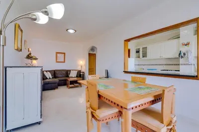 a dining room and living room with a wooden table at Falésia II - Nice Apartment - Vilamoura in Vilamoura
