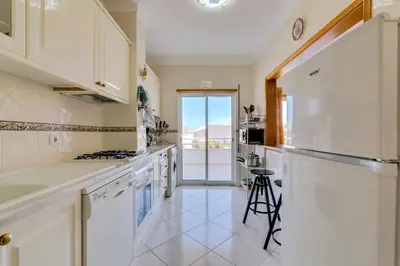a kitchen with white cabinets and a refrigerator at Falésia II - Nice Apartment - Vilamoura in Vilamoura