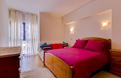 a bedroom with a large bed with red pillows at Paraísos do Pinhal - 2 Bedrooms - Vilamoura in Vilamoura