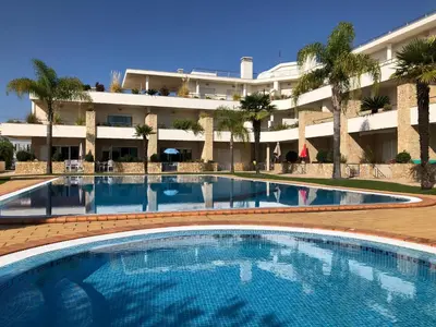 a large swimming pool in front of a building at Apartamentos Pomba Branca in Olhos de Água