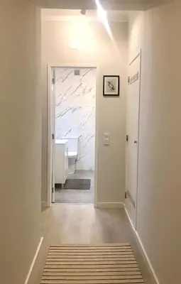 a hallway with a bathroom with a sink and a mirror at Paz na Areia in Quarteira