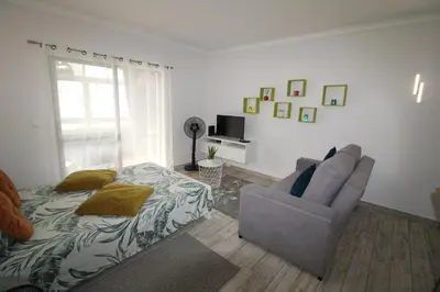 a bedroom with a bed and a couch and a chair at Apartamento T0 Albufeira perto do Centro in Albufeira