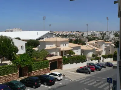 a parking lot with cars parked in front of houses at Apartamento T0 Albufeira perto do Centro in Albufeira