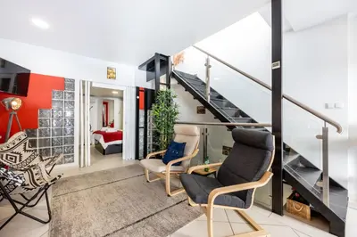 a living room with two chairs and a staircase at Townhouse N7 - Albufeira in Albufeira